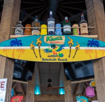 Tiki Hut bar with logo and alcohol bottles